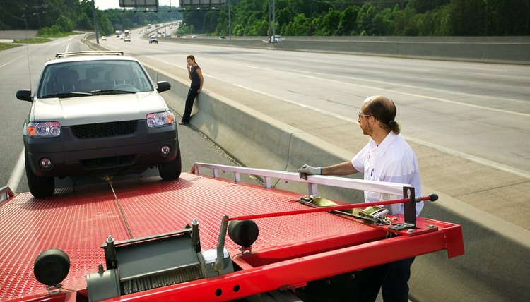 Tow truck driver loading car