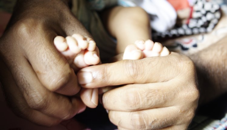 A man holding baby's feet