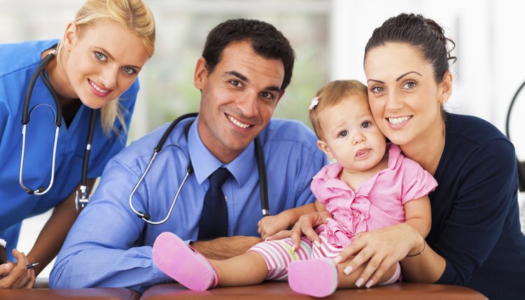 woman and baby girl with health workers
