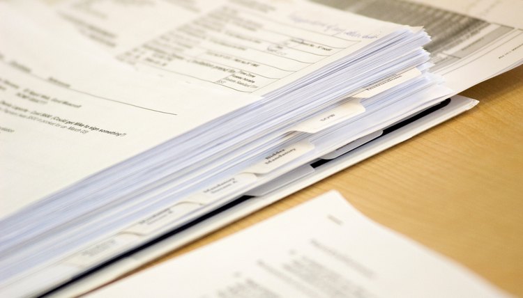 Binder with papers on office desk.