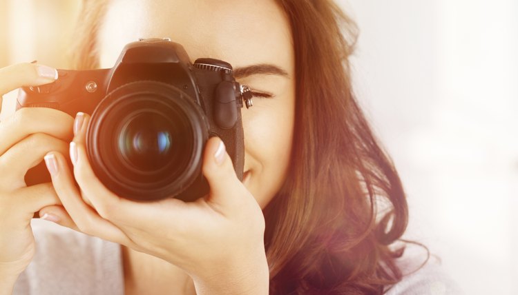 Pretty woman is a proffessional photographer with dslr camera
