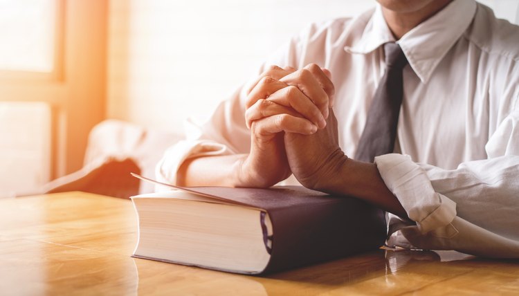close up, the pastor laid hands on the black book of the Bible, Buddhist, Catholic, Christian, prayer, and pray for blessings from God, all people are safe from harm.