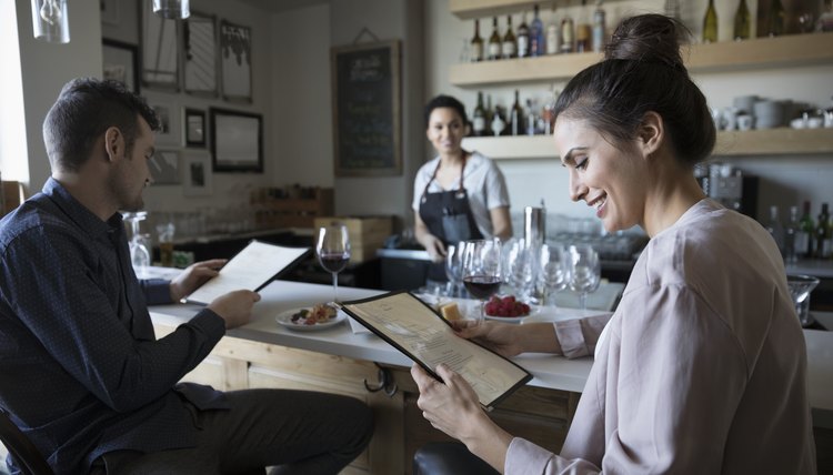 Young couple on date reading menu at bar