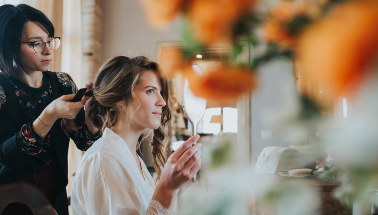 Bride preparing for wedding with hairstylist