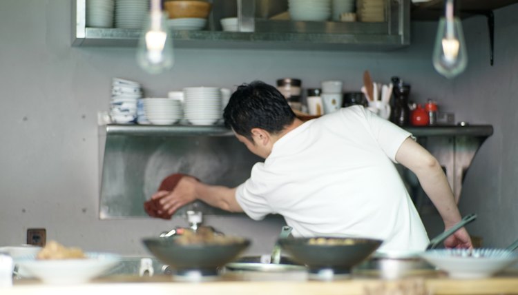 Man cleaning in a kitchen at Japanese pub