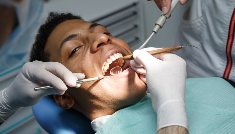 Doctor checking teeth of black man