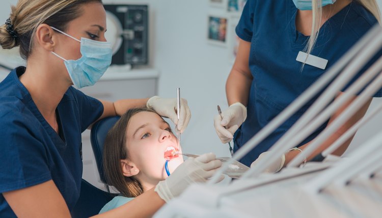 Pediatric dentistry. Dentist examining a young girl