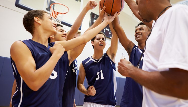 Male High School Basketball Team Having Team Talk With Coach