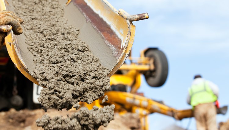 Construction Worker Guiding Cement Mixer Truck Trough