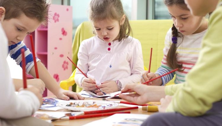 Group of children painting in classroom