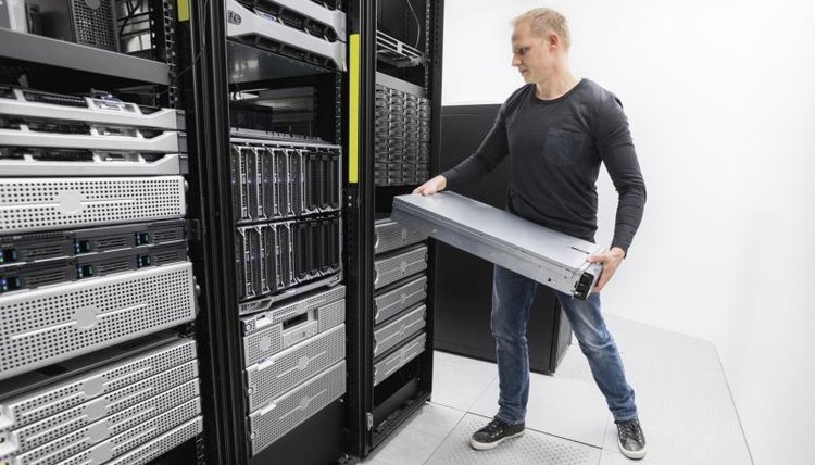 Image of an IT Technician installing a server rack.