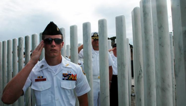 ROTC cadet salutes during ceremony at the USS Oklahoma Memorial in Pearl Harbor, Hawaii