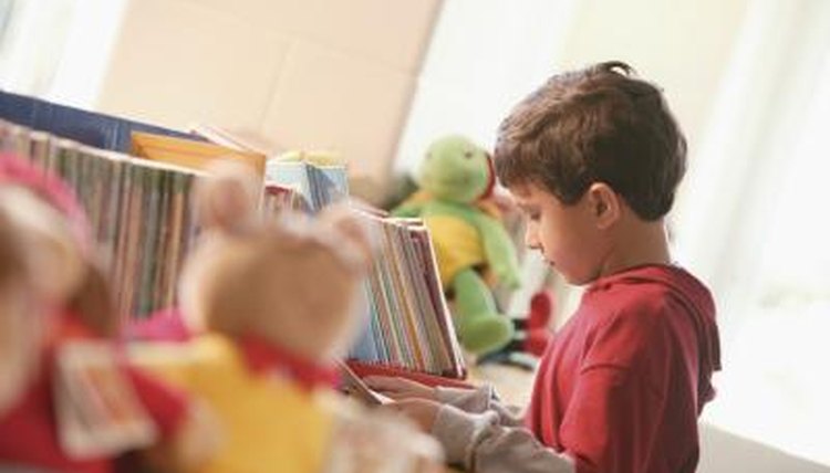 Little boy looking at book in library