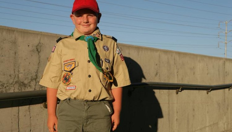 Boy scout standing outside in uniform.