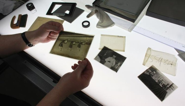 A student looking at photographs at a light table.
