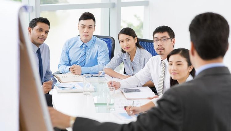 A young man gives a presentation to his fellow colleagues