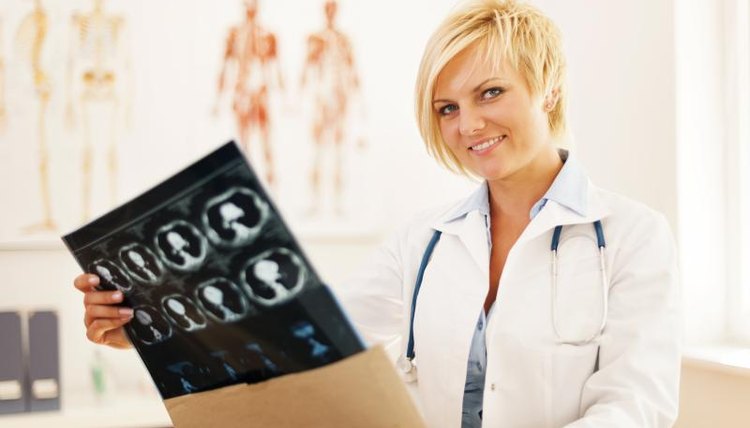 A doctor examines brain scan prints