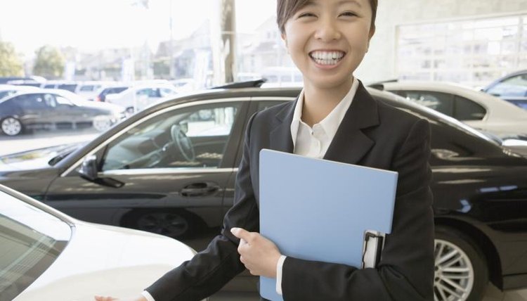 A female sales representative standing the show room of her dealership