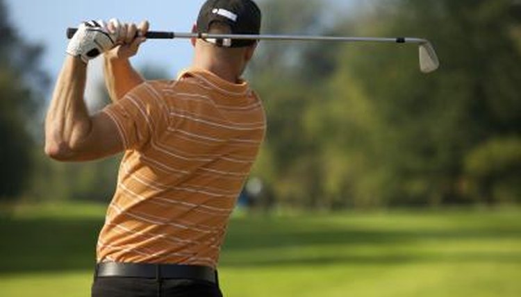 Rear view of a man swinging a golf club