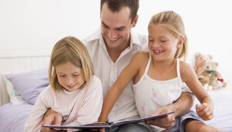 Father reading book with daughters