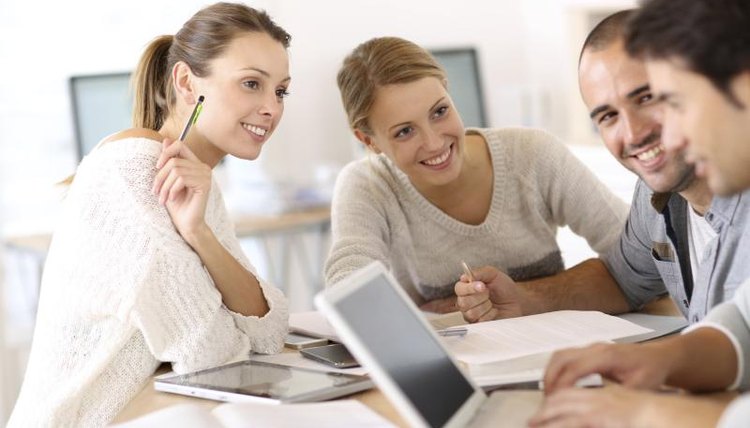 Students working together, surrounding another student with a laptop computer