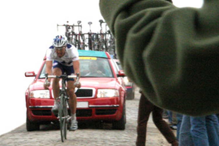 Un ciclista compitiendo en una carrera automovilística.