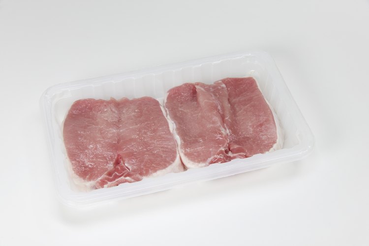 Cómo cocinar chuletas de cerdo envueltas en tocino en el horno.