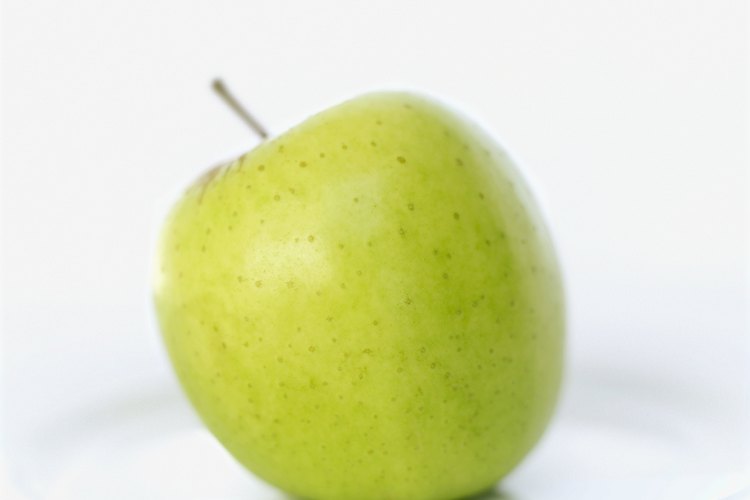 Una mujer suele comer manzana verde sobre un plato.