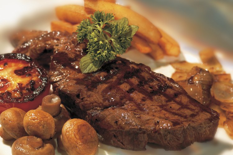 Las comidas derivadas de animales, como un filete, proporcionan vitamina B-12.