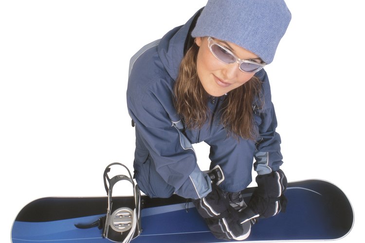 Snowboarder ajustando su tabla.