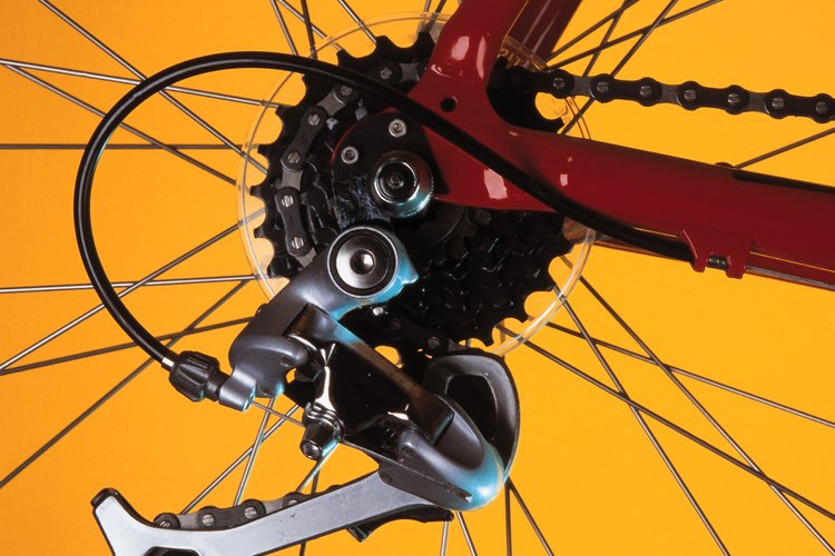 Una cadena de bicicleta va hacia la izquierda alrededor de la polea de montura y a la derecha alrededor de la polea de tensión.