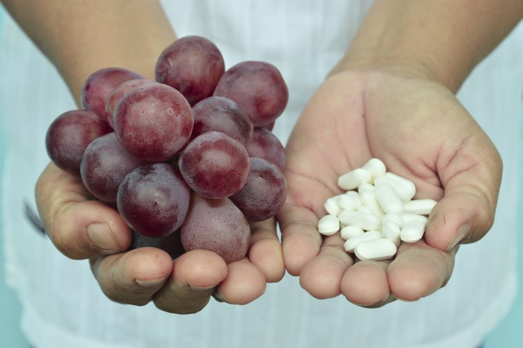 Mujer con uvas rojas y suplementos de semillas de uva.