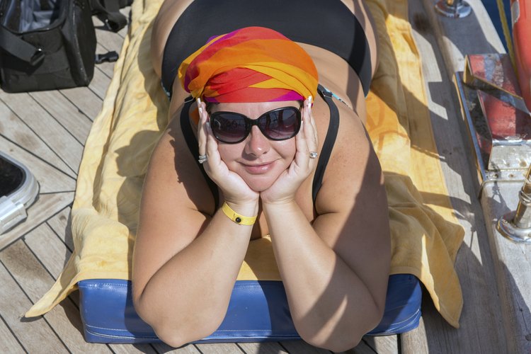 Una mujer posa para una foto mientras se broncea en la terraza de su patio.