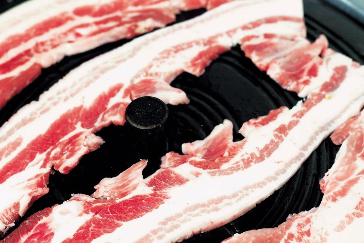 El nitrato de sodio le da al tocino crudo un color rosa y ayuda prevenir que se deteriore.