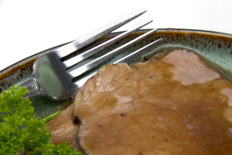 Sirve el asado con vegetales y una ensalada de hojas.