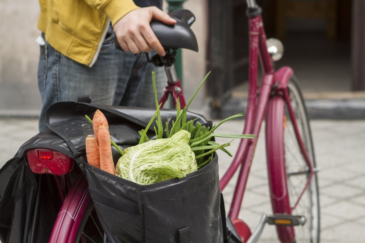 Un hombre toma un paseo en el mercado del agricultor en su bicicleta.