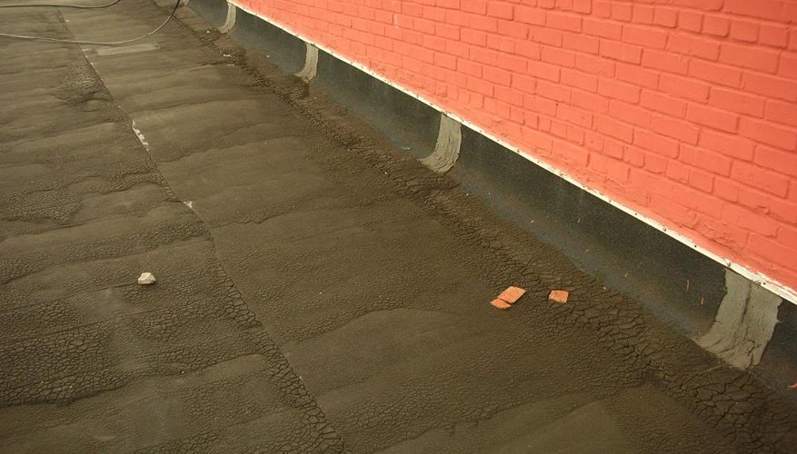 A brick wall next to an asphalt-covered roof. A brick wall next to an asphalt-covered roof.