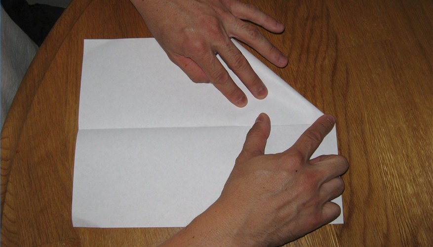 Fold the triangular tip of the plane. Fold the triangular tip of the plane.