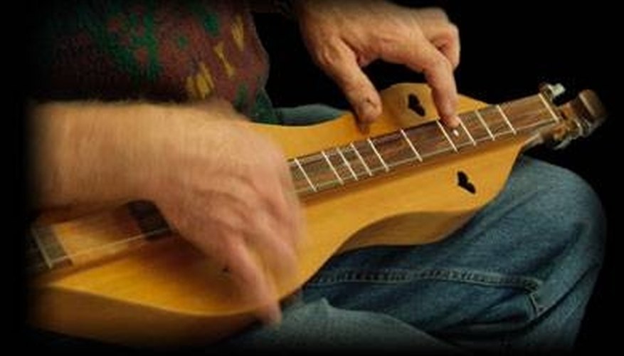 A man plays a finished mountain dulcimer