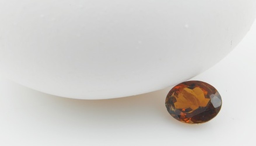 Photo Credit: garnet gem image by OMKAR A.V from <a href='http://www.fotolia.com'>Fotolia.com</a> Deep red to black is one of the color combinations for garnets.