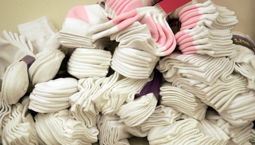 Photo Credit: pile of socks image by Adkok from <a href='http://www.fotolia.com'>Fotolia.com</a> Turn plain socks into gripper socks with puffy fabric paint.