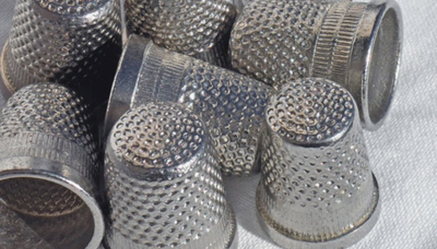 Photo Credit: thimbles - 3 image by JCVStock from <a href='http://www.fotolia.com'>Fotolia.com</a> Thimbles are used for tapping and dragging down the washboard.