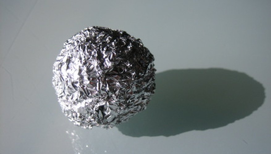Photo Credit: aluminiumkugel image by sun_orbiter from <a href='http://www.fotolia.com'>Fotolia.com</a> The foil ball will help clay retain its form when you add the facial details.