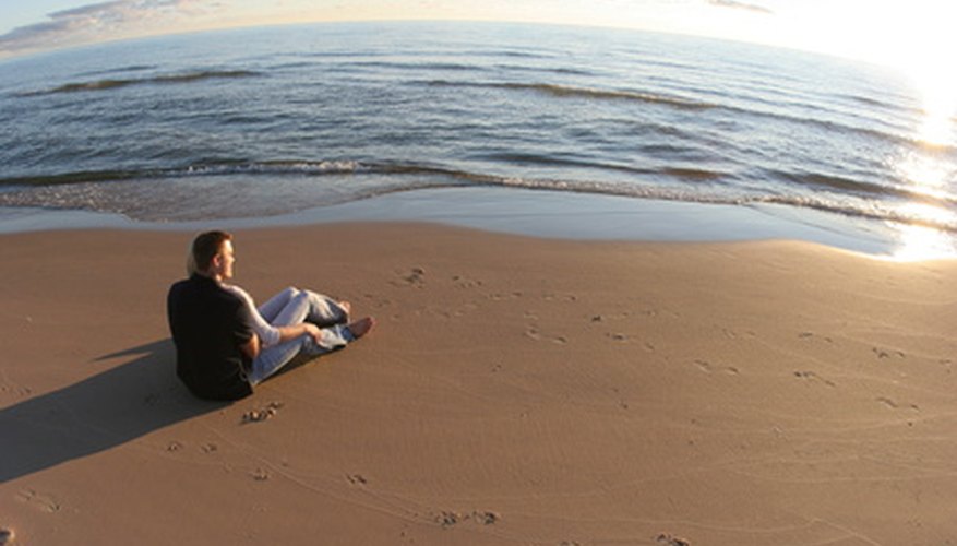 Photo Credit: couple sitting on beach sunset romantic image by Paul Retherford from <a href='http://www.fotolia.com'>Fotolia.com</a> Find agate in the Lower Peninsula on Lake Michigan beaches.