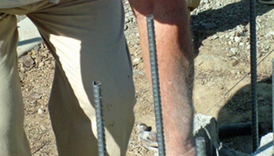 Vertical sections of rebar reinforce the strength of the concrete block wall. Vertical sections of rebar reinforce the strength of the concrete block wall.