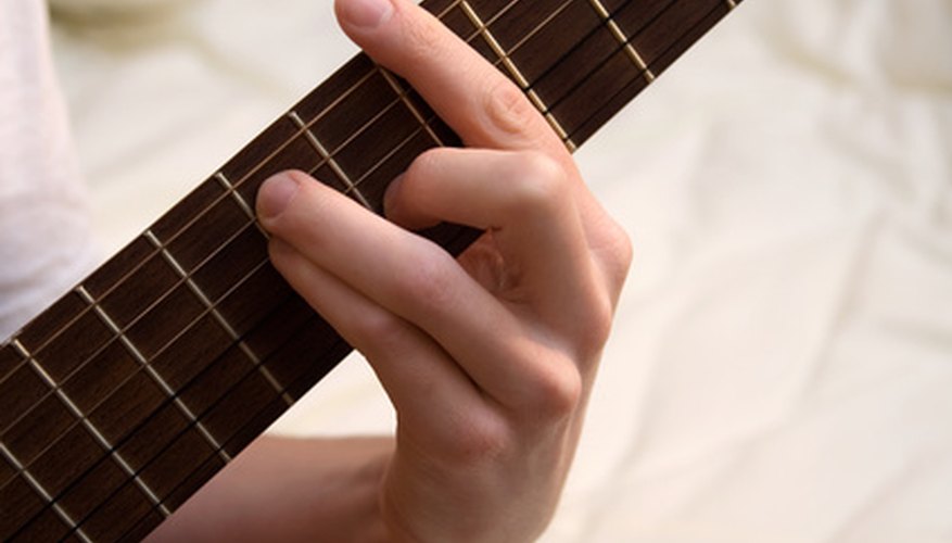 Photo Credit: guitar chord image by Alex Motrenko from <a href='http://www.fotolia.com'>Fotolia.com</a> Nylon strings make it easier to finger chords.
