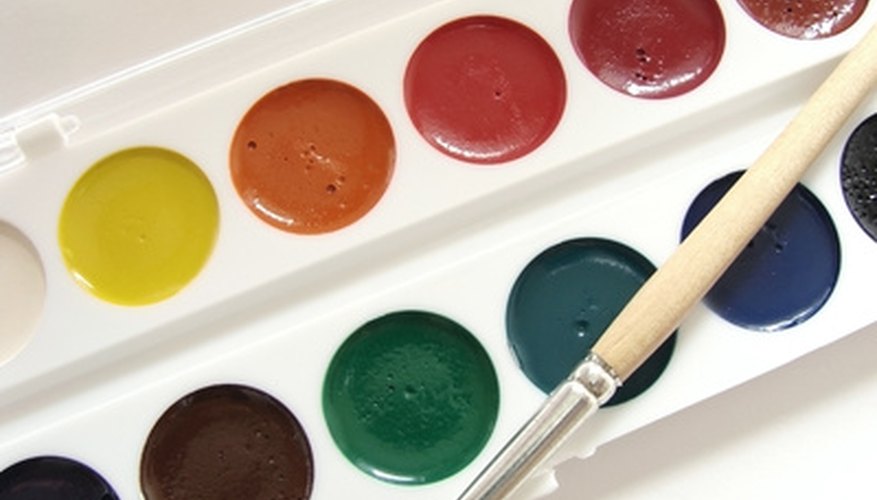 Photo Credit: watercolor paints image by DLeonis from <a href='http://www.fotolia.com'>Fotolia.com</a> A classic case of pan watercolors with brush.