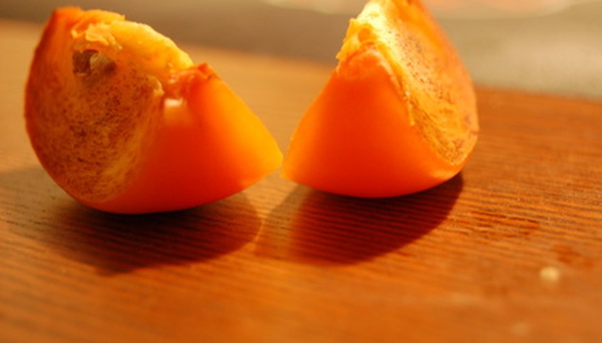 An Oriental persimmon tastes great when picked fresh off the tree. An Oriental persimmon tastes great when picked fresh off the tree.