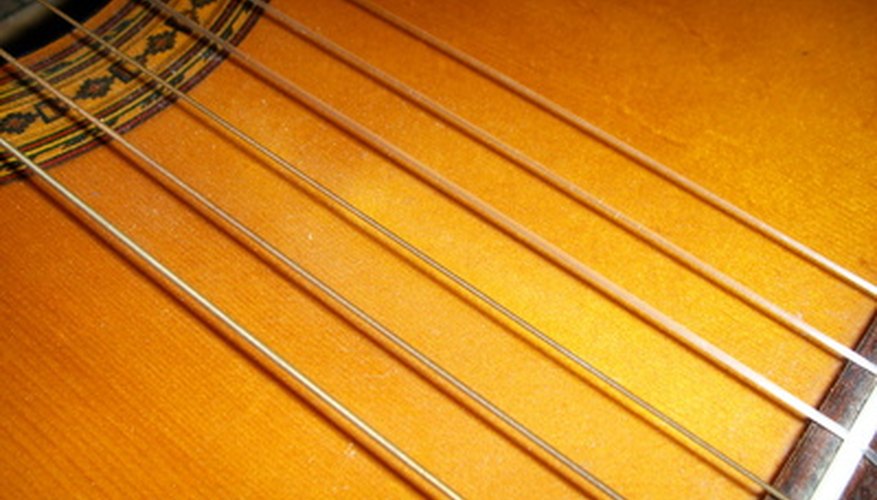 Photo Credit: Guitar strings. image by sabrihayes from <a href='http://www.fotolia.com'>Fotolia.com</a> Classical and folk guitars have different types of strings.