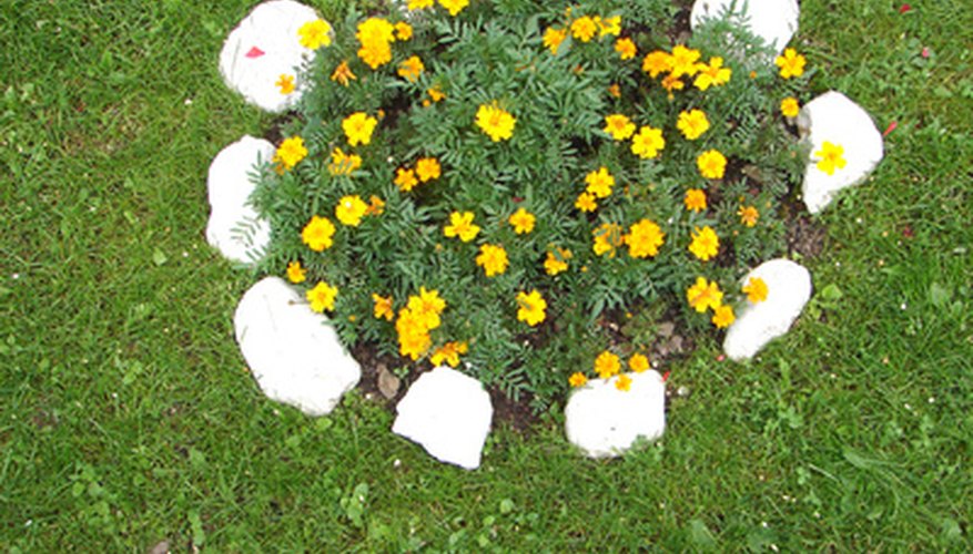 Simple stone edgings protect flower beds from mowers and trimmers. Simple stone edgings protect flower beds from mowers and trimmers.